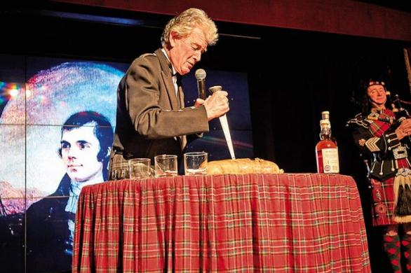 Ceremoniální rozříznutí haggisu se ujímají známé osobnosti – zde skotský moderátor Grant Stott.