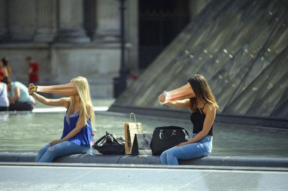 Dívky snažící se vecpat svůj ksicht do popředí Louvre.