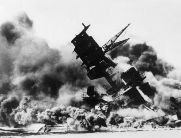 USS Arizona, americká bitevní loď třídy Pennsylvania, zasažená japonskými bombami a torpédy, se potápí. Uvězněno v jejích útrobách našlo smrt víc jak tisíc členů osádky.