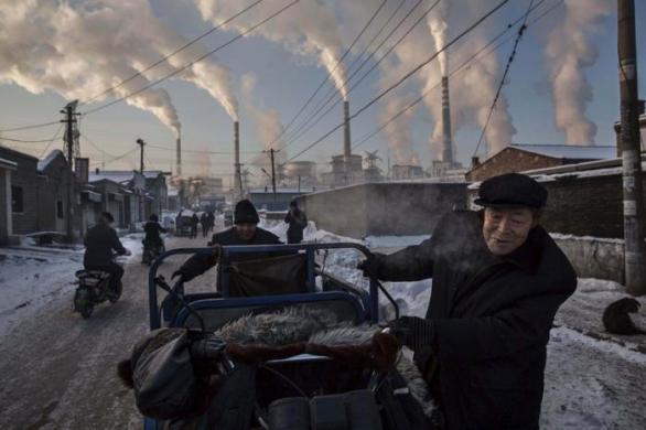 Číňan tlačí vozík nedaleko obří uhelné elektrárny. (Kevin Frayer, Kanada)
