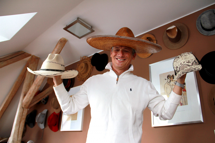 Na hlavě mexické sombrero, v pravé ruce kovbojský klobouk ze severního Mexika, v levé japonská baseballová čepičku z hadí kůže.