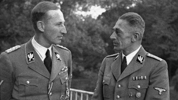 Dva Němci v hovoru, nebo Němec Heydrich rozmlouvá s Čechem Frankem, nebo říšský Němec hledí na českého Němce. Tři možnosti a všechny tři jsou správné. 