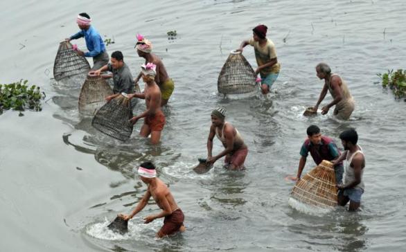 Indové v Assamu společně rybaří v rámci tradičního výměnného trhu Jonbee Mela, kde dostanete všechno, ale nic za peníze