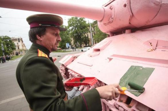 Muž v uniformě komunistické armády přemalovává tank. Neocitli jste se v časové smyčce, ale v Brně léta páně 2017.