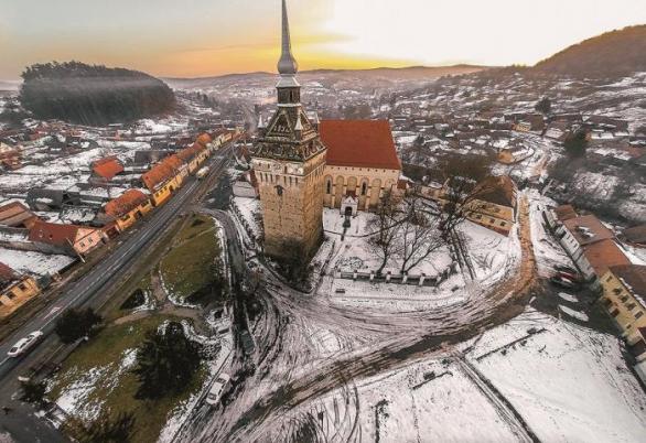 Saschiz / Keisd. Z asi 70 opevněných kostelů, roztroušených v hornaté krajině mezi městy Brašov, Bistrita a Sebes, jich je 8 zapsáno na seznam UNESCO. Saschiz je (i s místním hradem) jednou z nich. Stavba z 15. st. vyniká mohutnou soliterní obrannou věží.