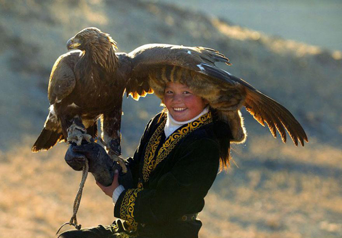 Třináctiletá kazašská dívka na lovu se svým orlem pokračuje v tradici svého otce. Pohoří Altaj, západní Mongolsko.