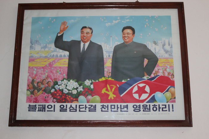 Kim Čong-il a jeho otec musí viset v každé severokorejské domácnosti a běda pokud není portrét denně oprašován.
