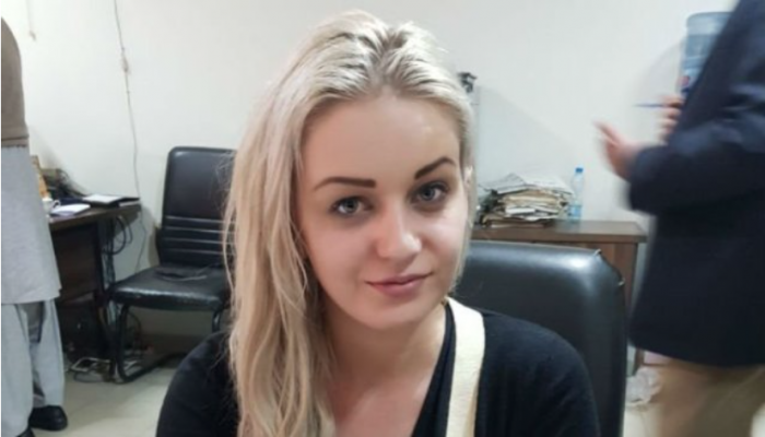 Tereza při výslechu na letišti. Všimněte si jejího úsměvu – vůbec jí nedochází, do jaké situace se svou hloupostí sama dostala a co ji čeká.