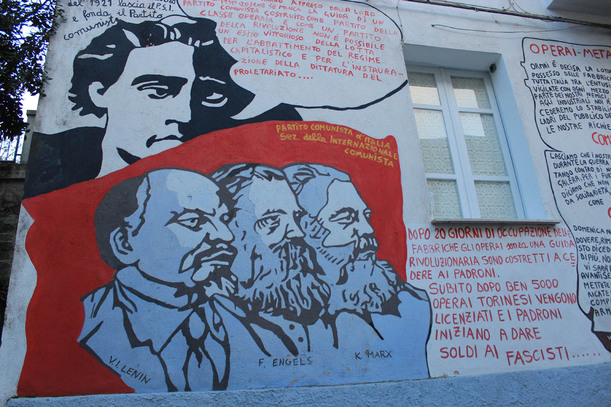 ‚Svatá trojice‘ levice: Marx, Engels, Lenin. Sardinie byla vždy ostře protifašistická, proletářská a plná levičáků. Není tedy divu, že zdi domů v Orgosolu zdobí komunističtí kmotři Marx, Engels a Lenin. 