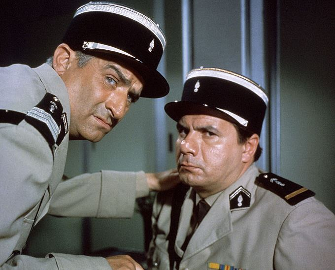 Četník v New Yorku (1965), na snímku s ním velitel Michel Galabru. Velitel: „Cruchote! Jsem krajně nespokojen! Italové jsou už kompletní a vysmívají se nám! Já mám jednu absenci a dva šašky!"