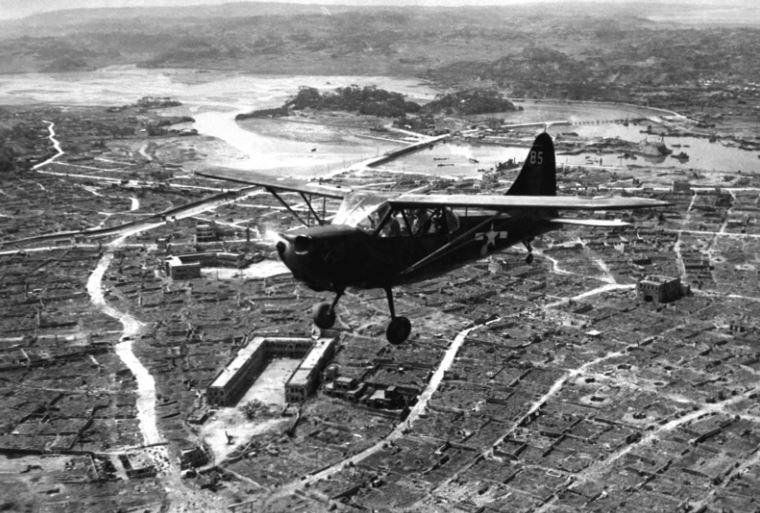 Americký průzkumný letoun Stinson Sentinel nad městem Naha, hlavním městem japonské prefektury Okinawa v květnu 1945.