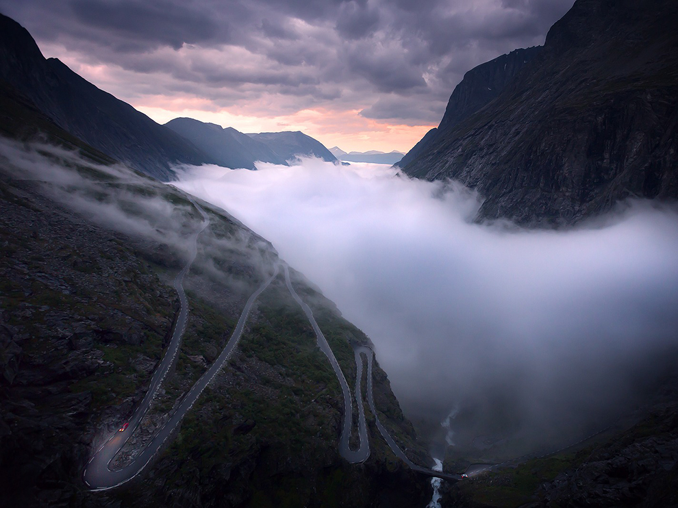 "Slavná klikatá silnice Trollsttigen v západním Norsku. V pozdním létě se údolí koupe v mlze."