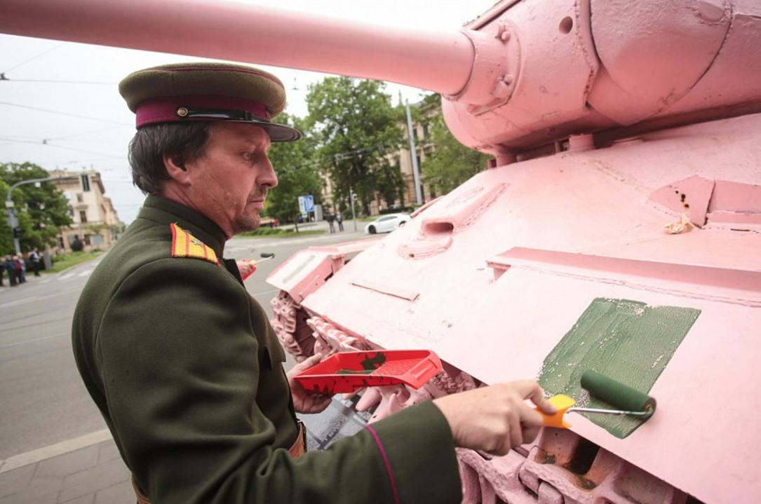 Muž v uniformě komunistické armády přemalovává tank. Neocitli jste se v časové smyčce, ale v Brně léta páně 2017.