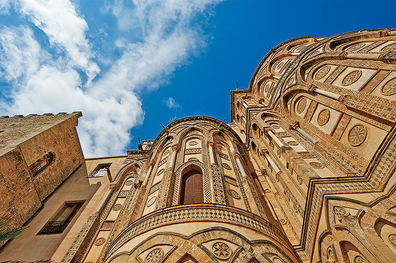 Neuvěřitelná vnější výzdoba románské baziliky v Monreale čnící vysoko nad Palermem.