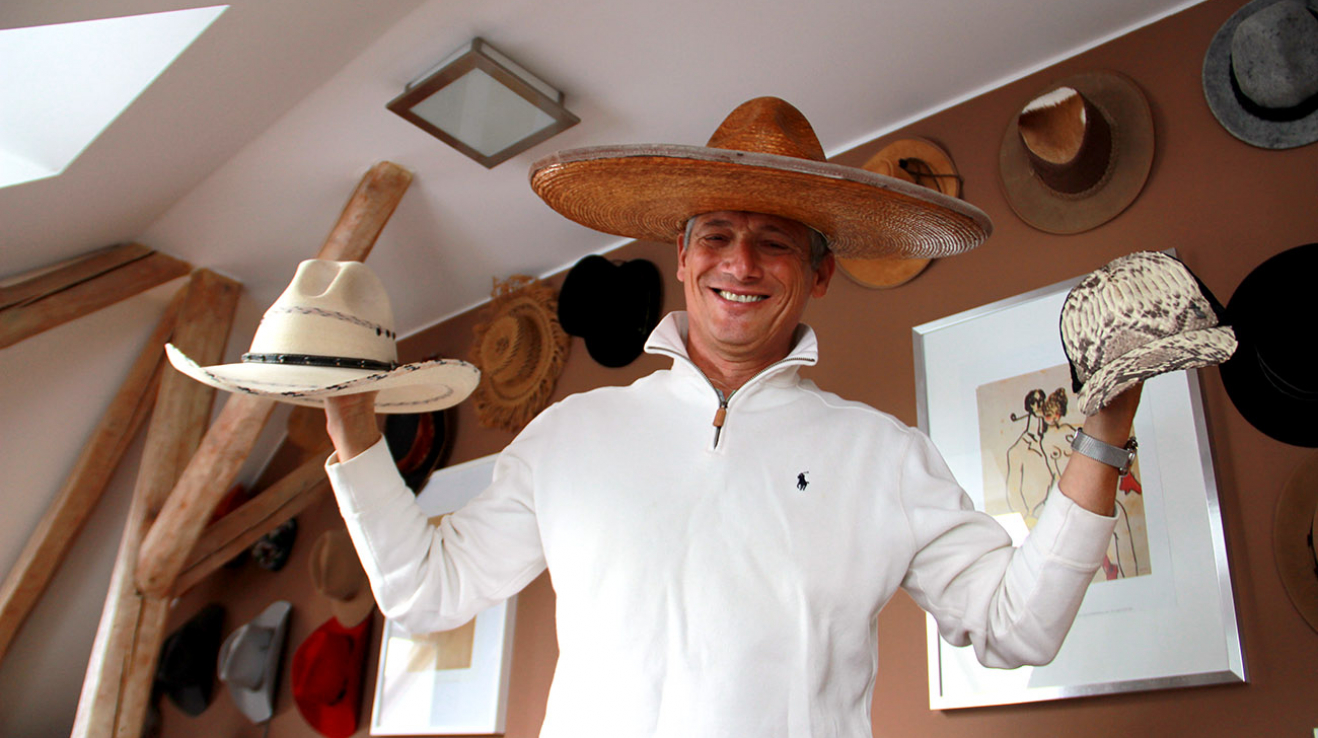 Na hlavě mexické sombrero, v pravé ruce kovbojský klobouk ze severního Mexika, v levé japonská baseballová čepičku z hadí kůže.