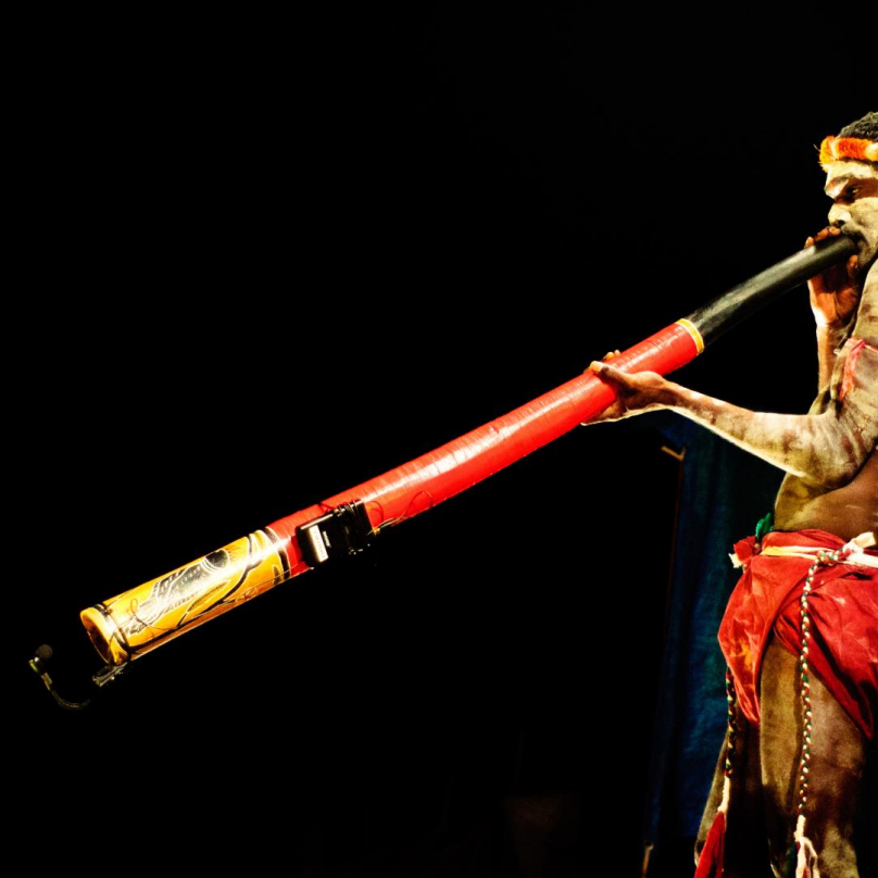 Aboriginec hrající na didgeridoo.