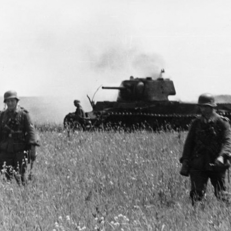 Postup německé pěchoty. Na pozadí zničený sovětský tank