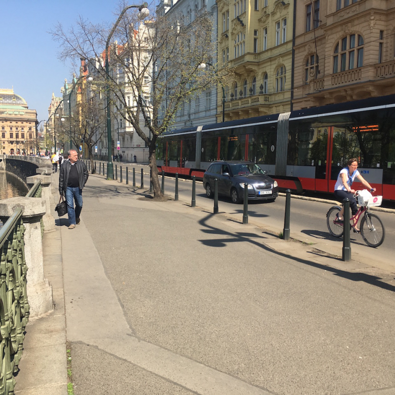 Chodník u Mánesa, kam cyklisté už nesmějí. Ráno jich po něm jezdí stovky. Paní na fotce jede po silnici, jak má. 